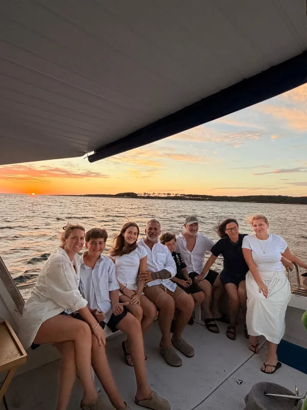 Grupo a bordo do barco privativo ao pôr do sol, com a Ilha Gorriti ao fundo