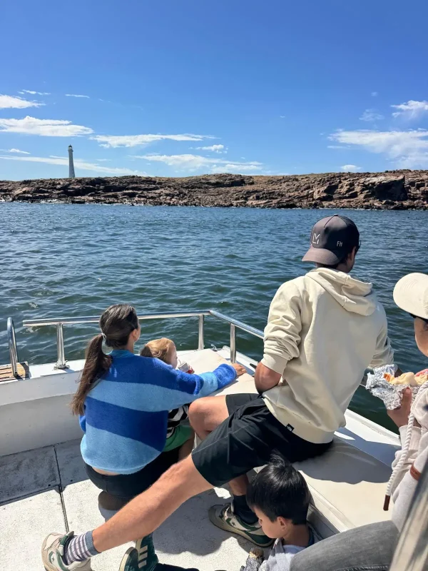 Family aboard the private boat looking at Isla de Lobos and its lighthouse