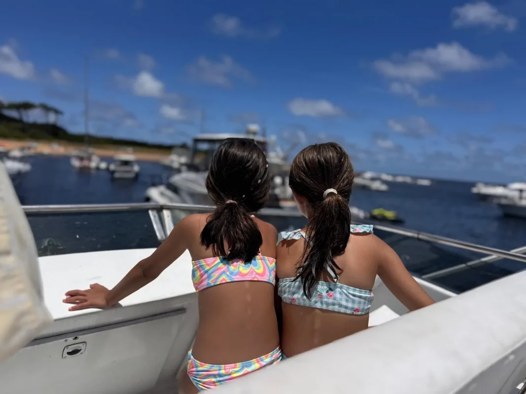 Meninas a bordo olhando os barcos ancorados na Ilha Gorriti, Punta del Este