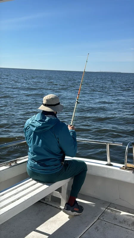 Angler aboard a private boat with Isla de Lobos on the horizon
