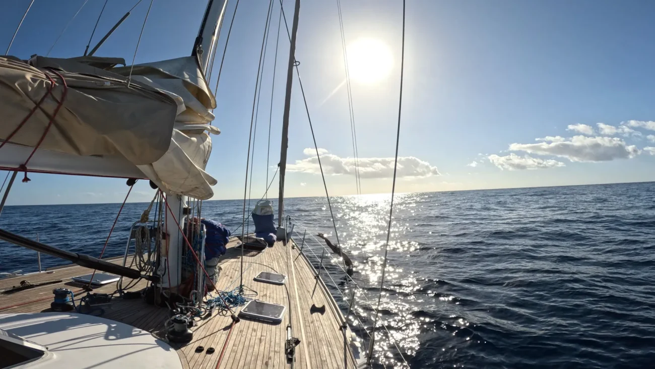 Convés do veleiro com o sol sobre o mar